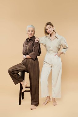 Bir anne ve kız birlikte poz verirken moda anlayışlarını ve bağlantılarını gösterirler..