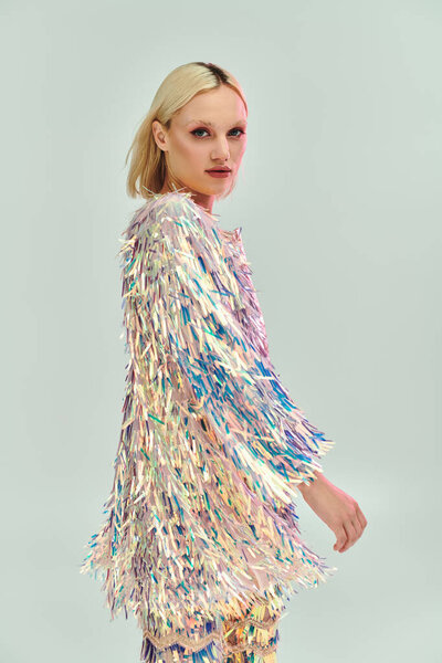 A stylish young woman displays a vibrant, shimmering outfit.