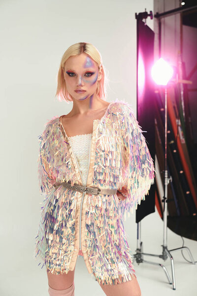 Молодая женщина демонстрирует свой стиль моды вперед с яркими голографическими элементами.