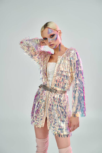 Стильная молодая женщина представляет свой голографический наряд с равновесием.