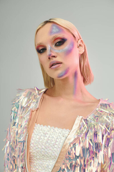 Сияющая молодая женщина демонстрирует свой голографический наряд с игривым выражением лица.