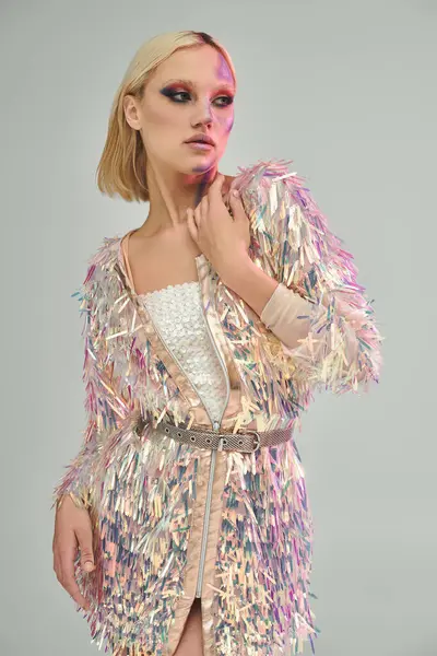 stock image A chic young woman showcases her stunning holographic outfit with confidence.