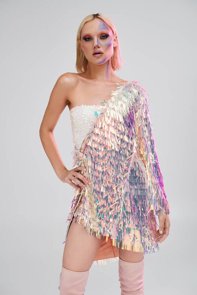 Модная молодая женщина с уверенностью демонстрирует потрясающий голографический наряд.