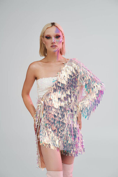 Молодая женщина излучает элегантность в своей голографической одежде, воплощая современную моду.