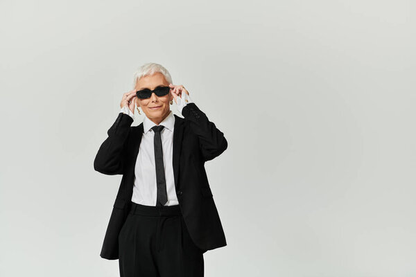 Зрелая женщина демонстрирует свой модный вид, излучая уверенность и стиль.