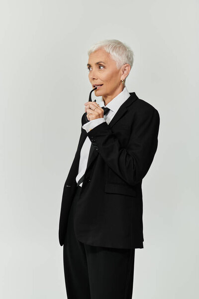 Confident woman showcases her chic style while pondering elegantly.