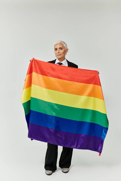 A stylish woman proudly displays a rainbow flag, symbolizing love and inclusivity.