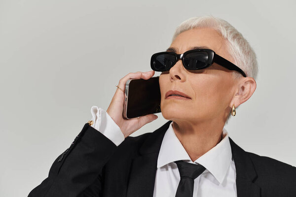 Стильная женщина наслаждается энергичным разговором, излучая изысканность.