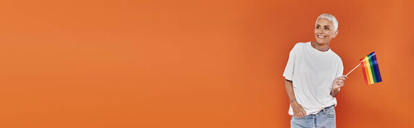 Confident woman waves rainbow flag in celebration of love and inclusivity.