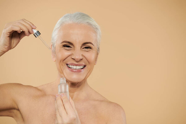 A joyful moment as a woman using face serum.