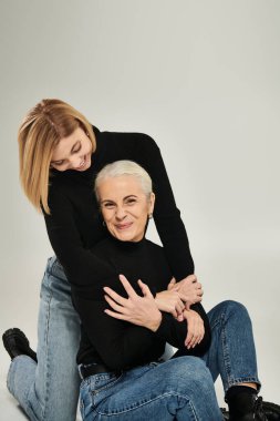 A woman and her daughter share a warm embrace and joyful laughter. clipart