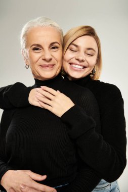 Bir anne ve kızı, sevgi ve sıcaklık saçan neşeli bir kucaklaşmayı paylaşır..