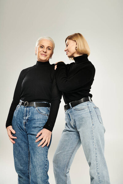 Two women share a playful connection while dressed in fashionable attire.