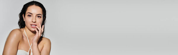 Красивая женщина позирует с уверенностью, демонстрируя уход за кожей.