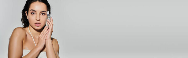 Молодая женщина представляет свою рутину кожи с элегантностью и уверенностью.