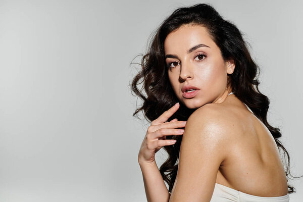 Активная поза брюнетки с длинными волосами в купальнике.