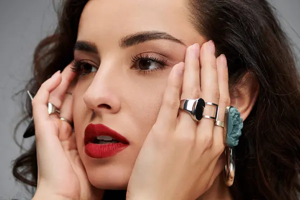 stock image Beautiful woman highlights her jewelry while striking an elegant pose.