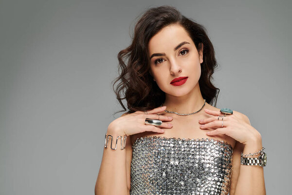 Красивая женщина элегантно подчеркивает свои украшения на ярком фоне.