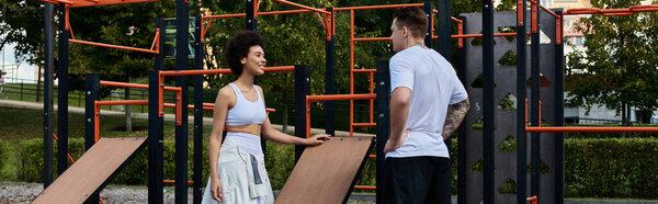 Two friends are motivating each other during an outdoor fitness session in a vibrant park.