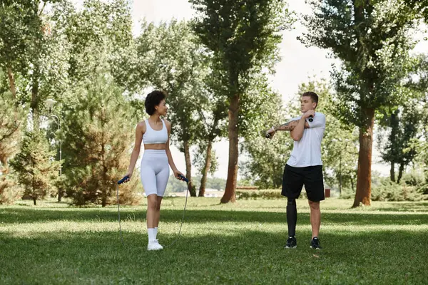 stock image Two friends exercise in a park, showcasing determination and friendship through inclusive fitness.