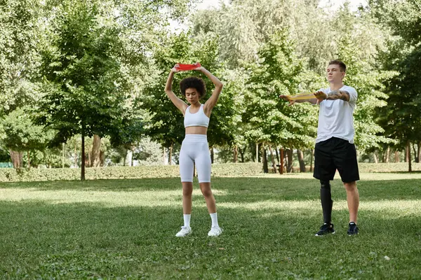 Stock image Two friends are actively working out together in a lush green park, showcasing strength and camaraderie.