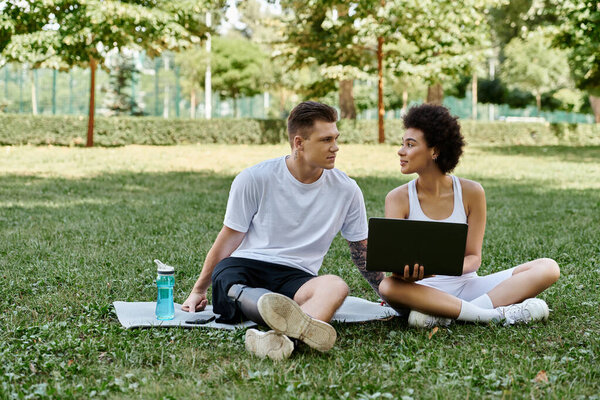 Two friends training outdoors together, showcasing strength, support, and friendship in a vibrant park setting, using laptop