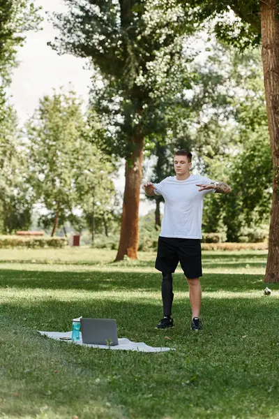 Yeşil Park 'ta çalışan dövmeli adam, online fitness dersi alıyor.