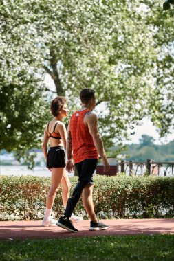 Two friends enjoying an outdoor workout, showcasing strength and camaraderie in a sunny park. clipart