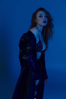 Kendine güvenen bir kadın moda anlayışını açık mavi bir ortamda sergiliyor..