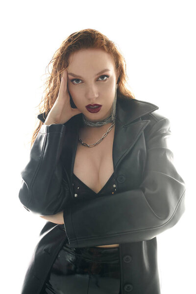 A striking figure poses confidently with an alluring gaze and bold attire.