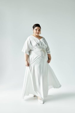 Göz kamaştırıcı bir gelin beyaz bir gelinlik içinde zarif bir şekilde poz vererek güzellik saçar..