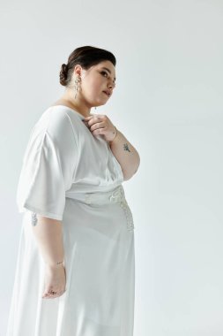 Güzel, büyük beden bir gelin, beyaz bir gelinlik içinde, küpelerini ön plana çıkarıyor..