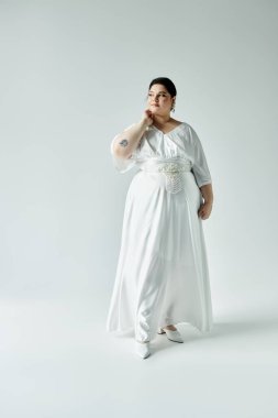 Işıl ışıl bir gelin, dalgalı beyaz bir gelinlik ve pırıl pırıl küpeler içinde güzelliğini sergiler..