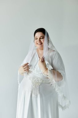 Dalgalanan beyaz elbisesi ve narin küpeleriyle neşeli bir gelin özel anını incelikle kucaklıyor..