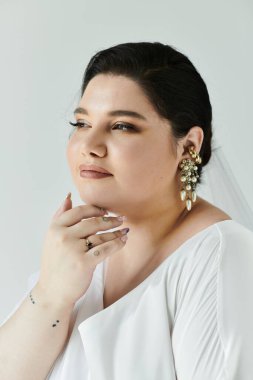 Güzel, genç bir gelin, neşe saçan elbisesi ve pırıl pırıl küpeleriyle neşe saçıyor..