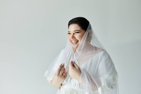 A joyful bride in a graceful white gown shines with elegance, adorned with beautiful earrings and a veil.
