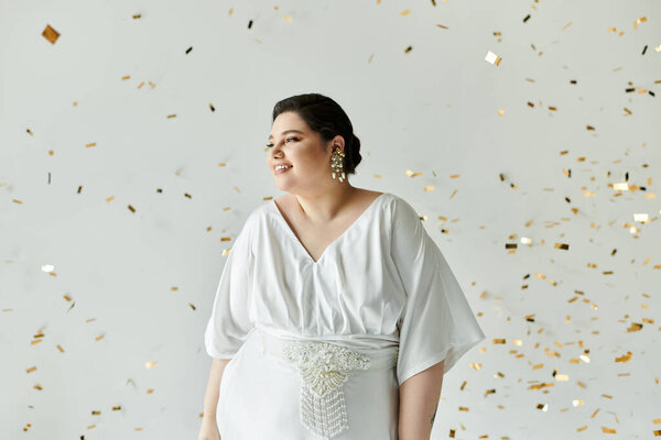 A stunning plus-size bride glows in her white gown, adorned with sparkling earrings against a chic backdrop.