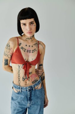 Genç bir kadın benzersiz dövmelerini ve şık görünümünü sergiliyor..