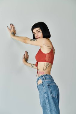 Modaya uygun bir kadın dövmelerini gösteriyor, içeride cesur bir poz veriyor..