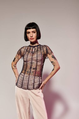 Modaya uygun bir kadın sanatsal bir stüdyoda rahatça poz veriyor..