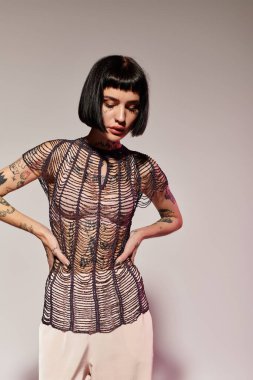 Zarif kadın kendine güvenerek dövmelerini ve şık kıyafetlerini gösteriyor..