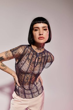 Kendine güvenen genç bir kadın moda anlayışını ve benzersiz dövmelerini sergiliyor..
