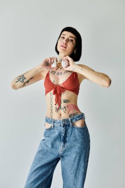 Şık bir kadın moda kıyafetleri içinde poz verirken kendine güvenerek dövmelerini sergiliyor..