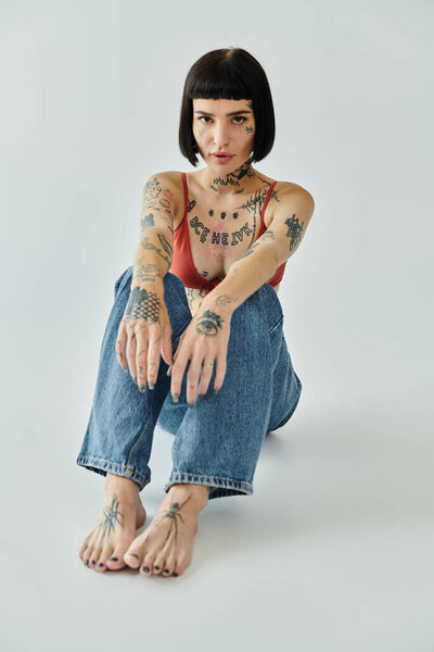 Модная женщина с татуировками демонстрирует свой уникальный стиль.