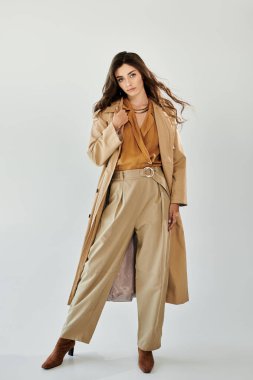 Genç ve güzel bir kadın modaya uygun bir sonbahar kıyafetiyle modern moda atmosferini yakalıyor..