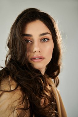 Modern bir stüdyo ortamında zarafet ve cazibeyi ön plana çıkaran zarif bir sonbahar görünüşü içinde ışıldayan zarif genç bir kadın..