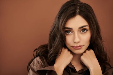 Genç bir kadın şık bir sonbahar elbisesi içinde cazibesini sergiliyor. Stüdyo ortamında mevsimlik stil ve zarafet sergiliyor..