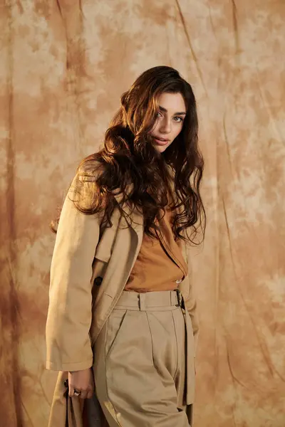 stock image A young and beautiful woman smiles while posing in a chic autumnal outfit, embodying seasonal elegance and style.