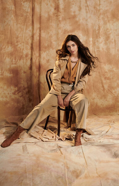 A young woman exudes confidence in her autumn ensemble, combining warmth and style in a vibrant studio ambiance.