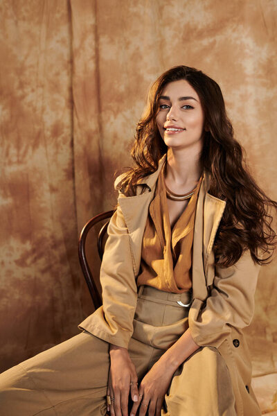 Молодая женщина излучает уверенность в шикарном осеннем наряде, смешивая тепло и стиль в уютной студии.